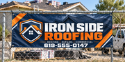 Custom roofing vinyl banner mounted on a worksite fence